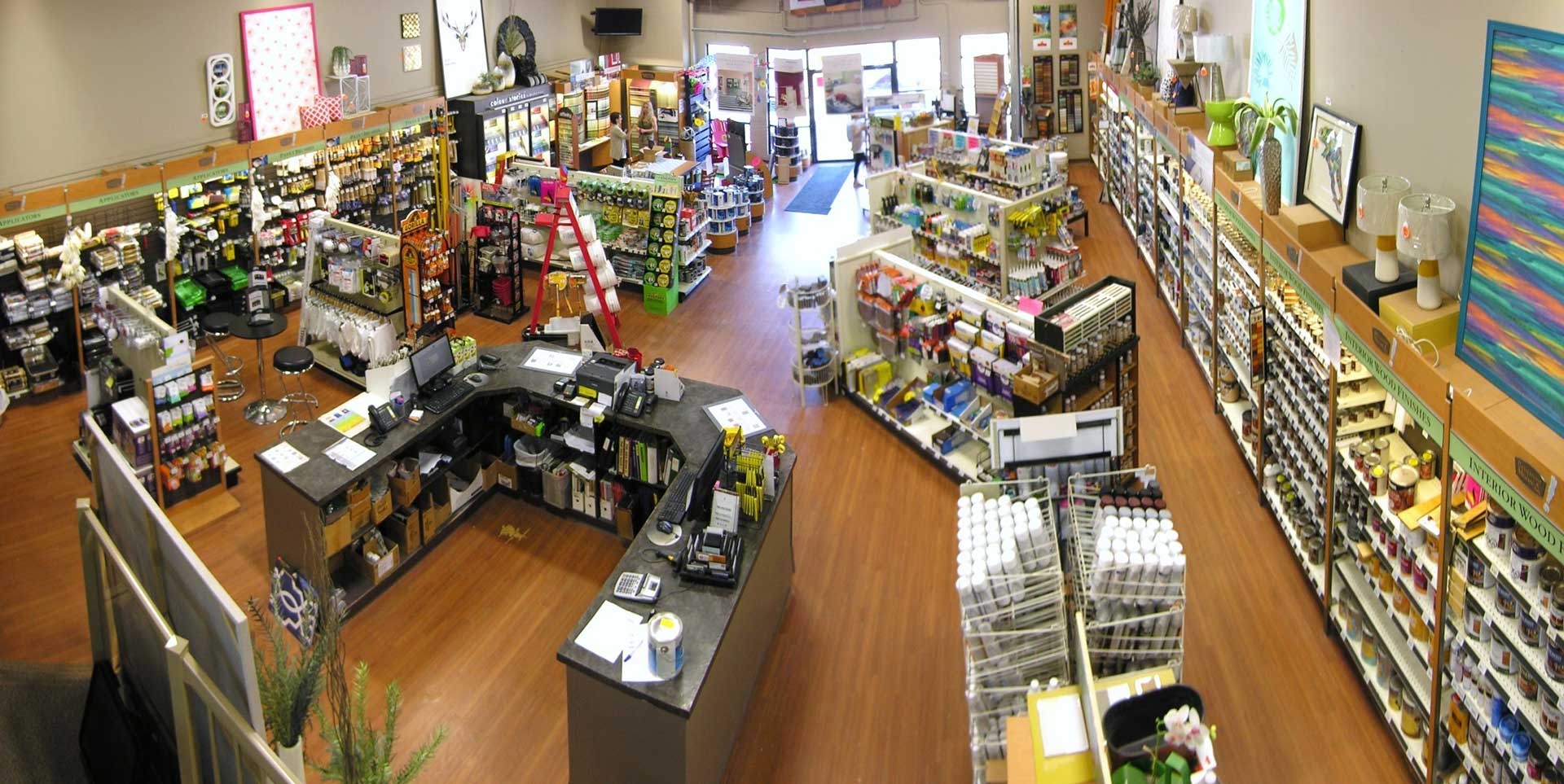 The inside of a paint store with many shelves of paint cans and painting supplies