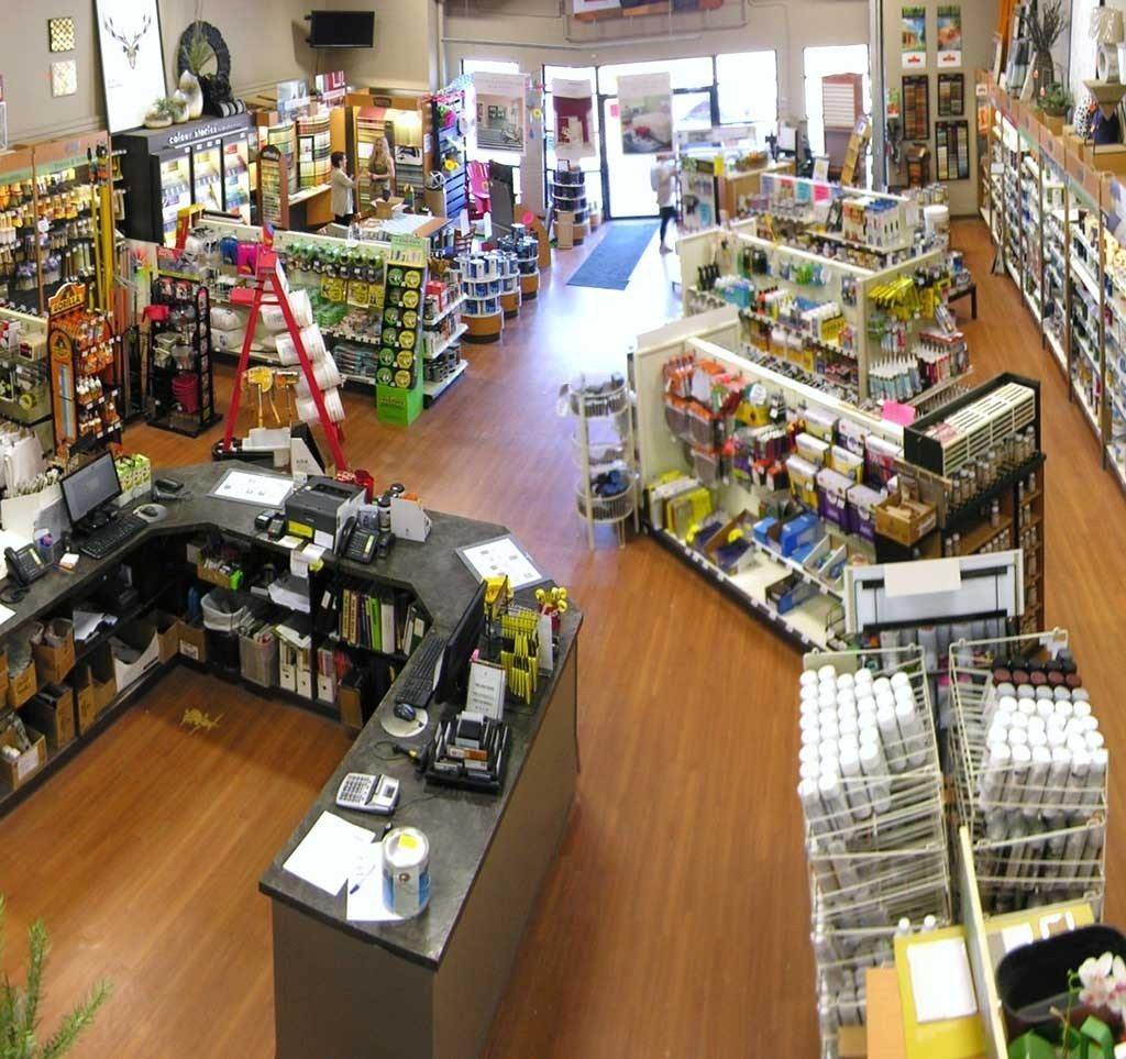 The inside of a paint store with many shelves of paint cans and painting supplies